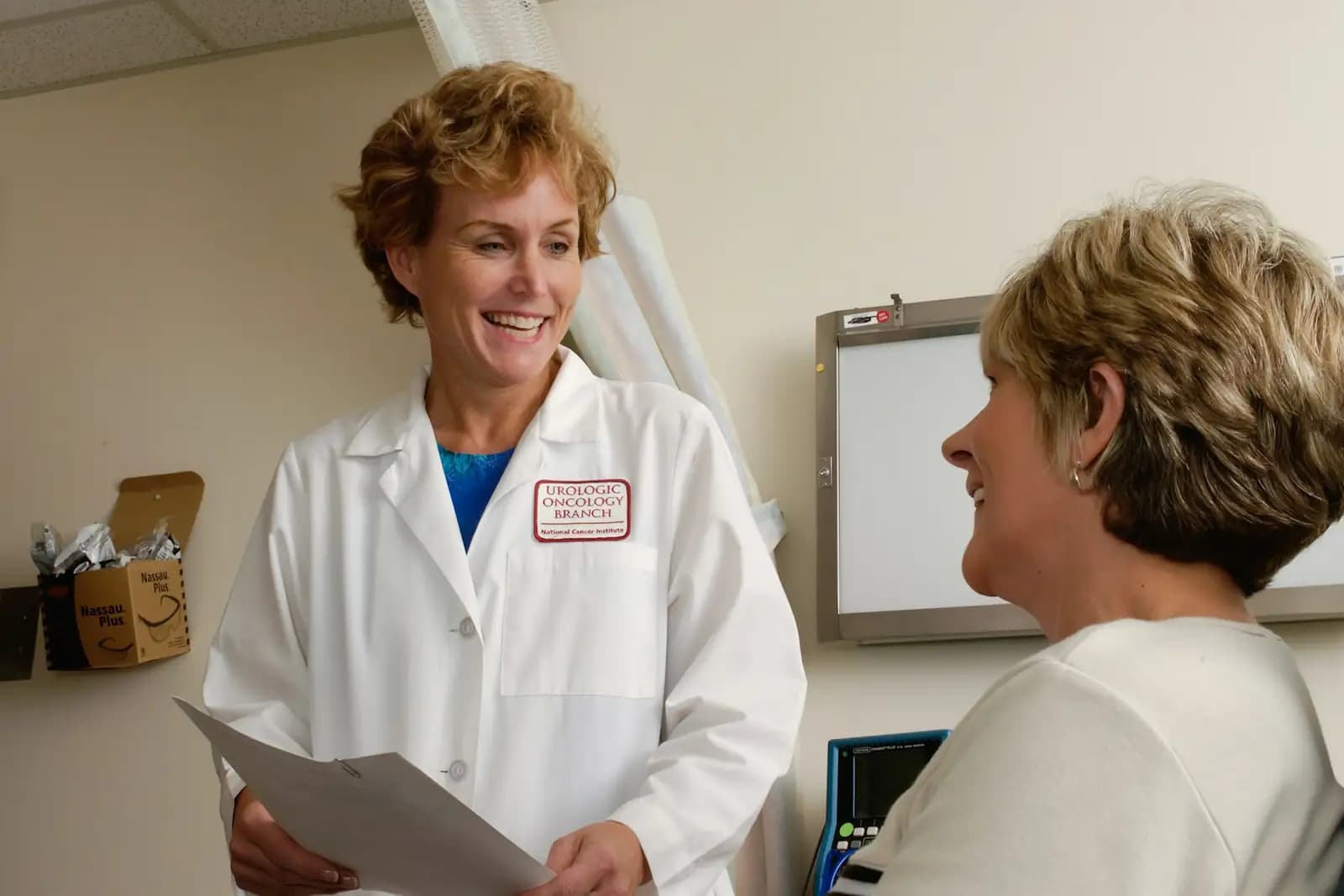 A doctor in a white coat talking with a patient in a clinic